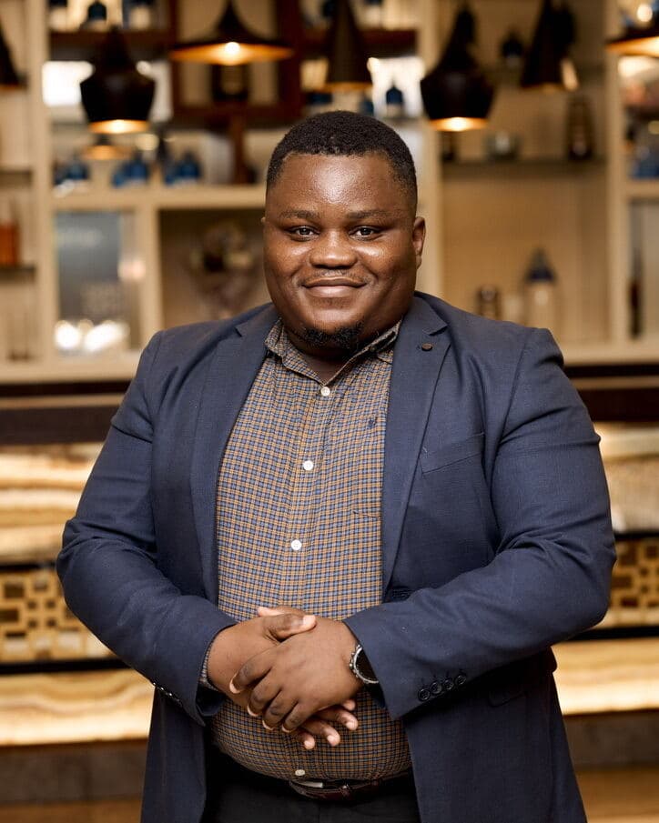 Mawuli Dzaka, founder of Nkonso, in a dark blazer, smiling